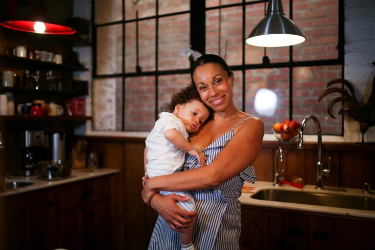 Mother holding her child in a warm kitchen at the end of the day